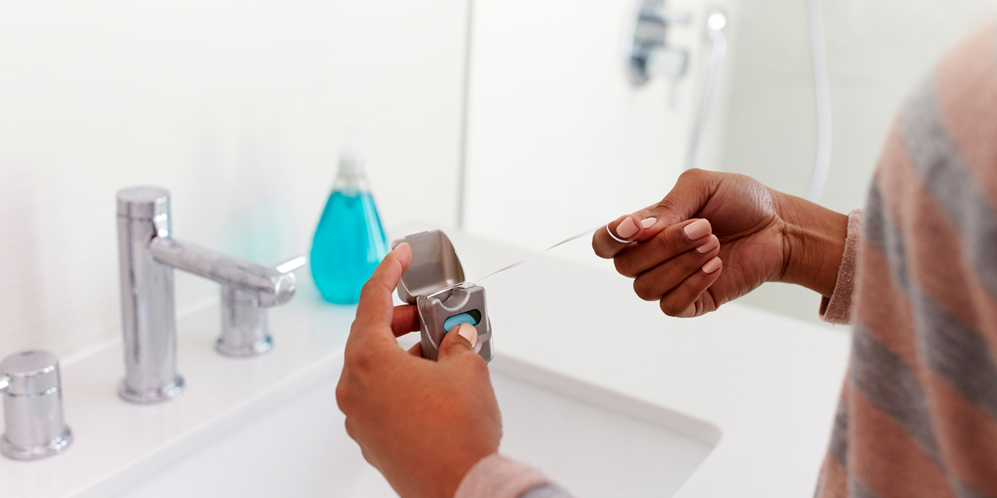 Person flossing in home bathroom (2)
