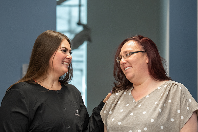 patient and staff member smiling together