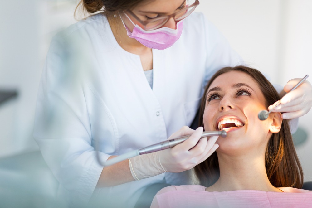 Girl in dental chair getting her teeth cleaned by dental hygenist