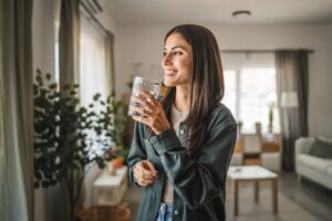 Lady in her homan drinking juice happy because she received dental work